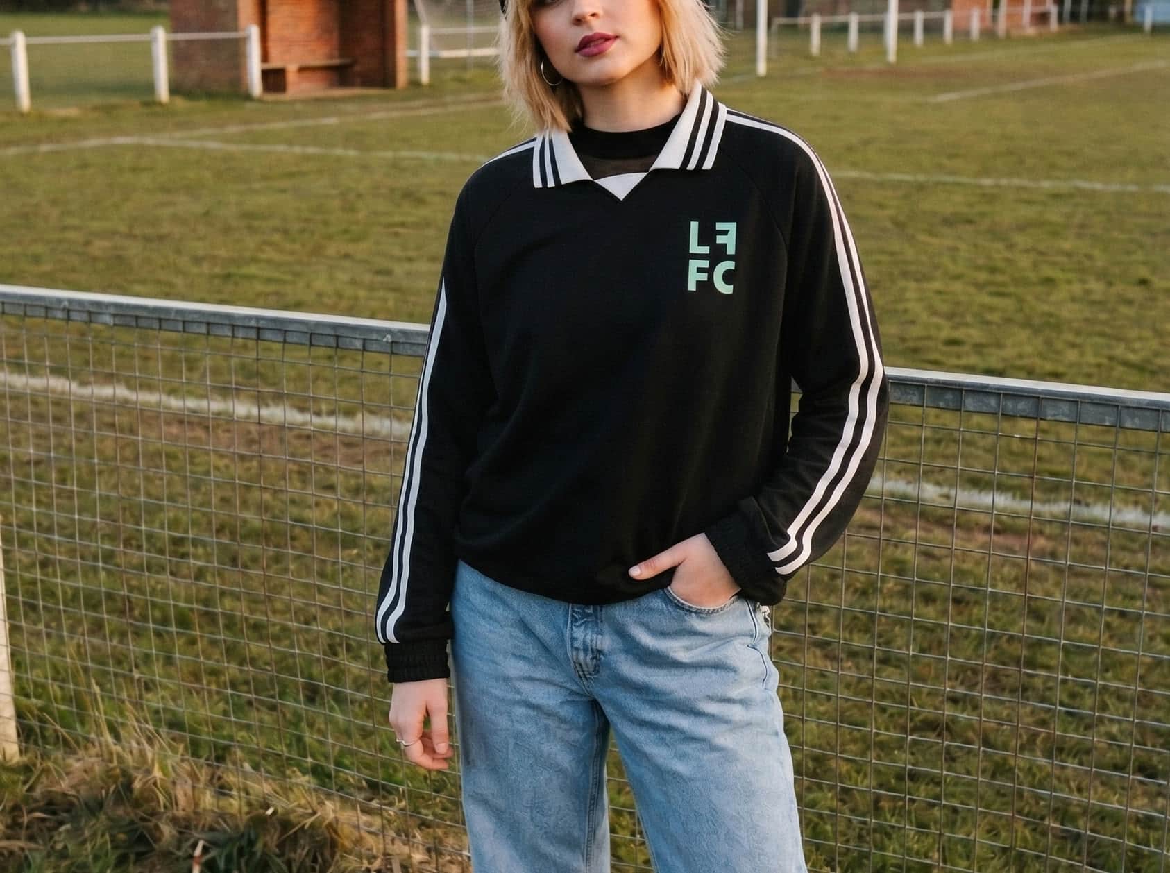 A supporter wearing the black collared jersey with white sleeve stripes