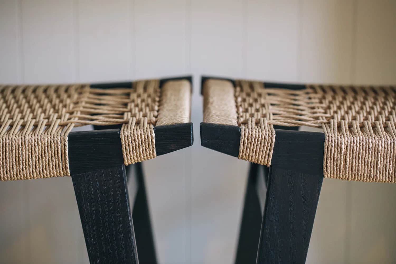 Two ebonised oak stools with woven Danish cord seats, made by Monica Cass at Par-Avion