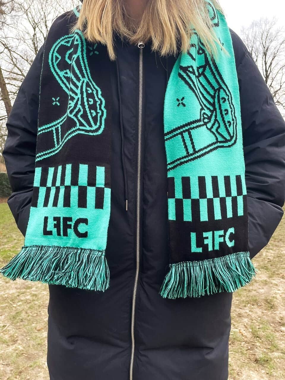 The club scarf worn over a winter coat